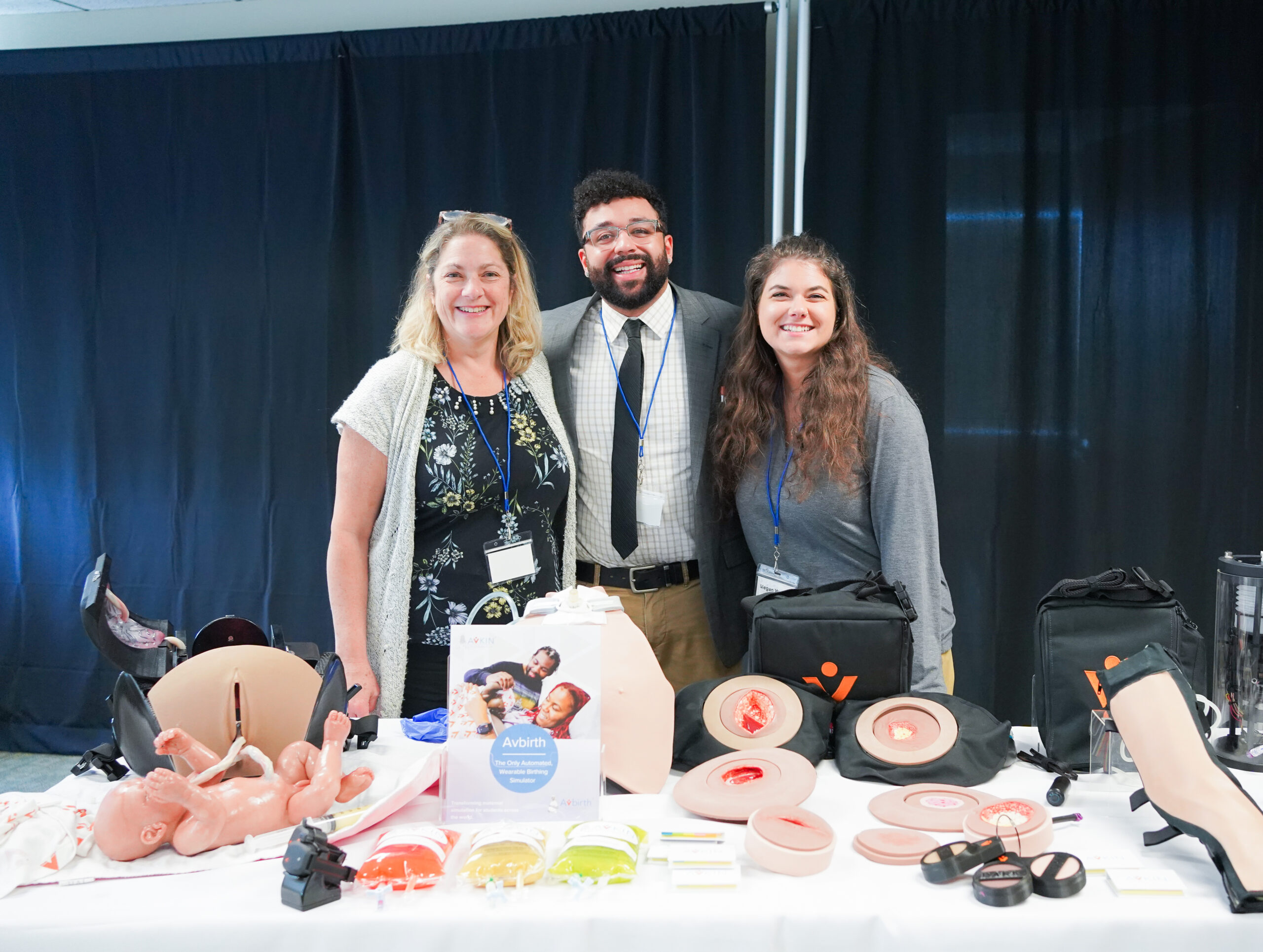 Amy Cowperthwait, Royce Townsend and Megan Weldon of Avkin pose with wearable simulators at SIM Summit George Washington University