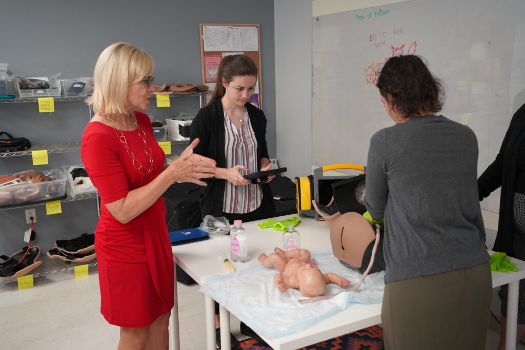 President of the Delaware Nurses Foundation, Dr. Bethany Hall-Long, studies Avkin's Avbirth - The World's Only, Fully-Automated, Wearable Birthing Simulator
