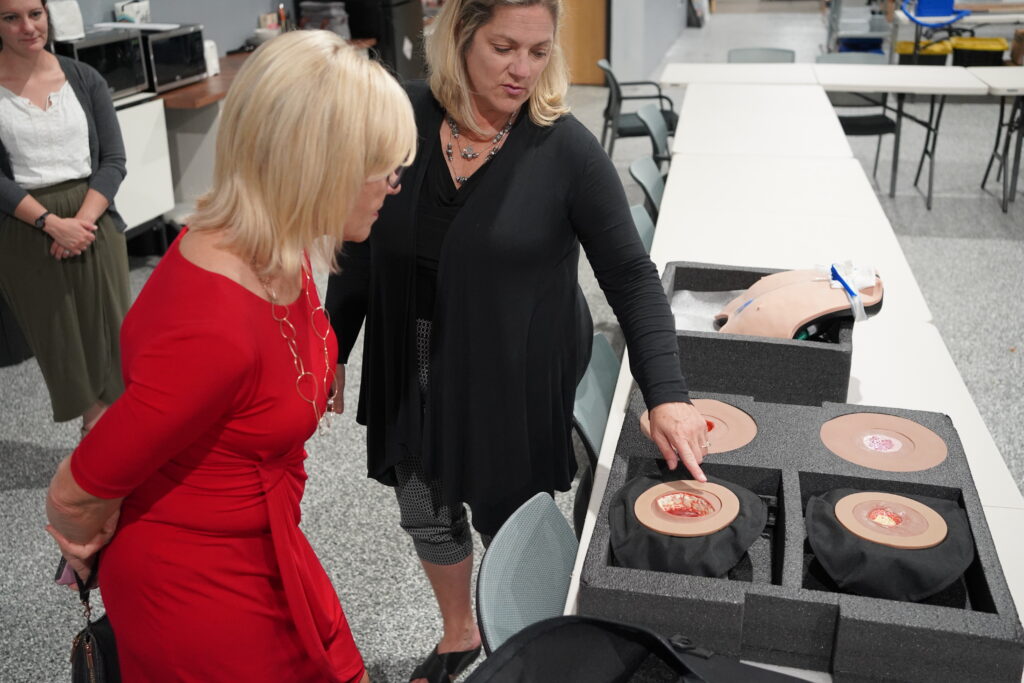 President of the Delaware Nurses Foundation, Dr. Bethany Hall-Long, studies Avkin's Awound - A wearable wound care simulator
