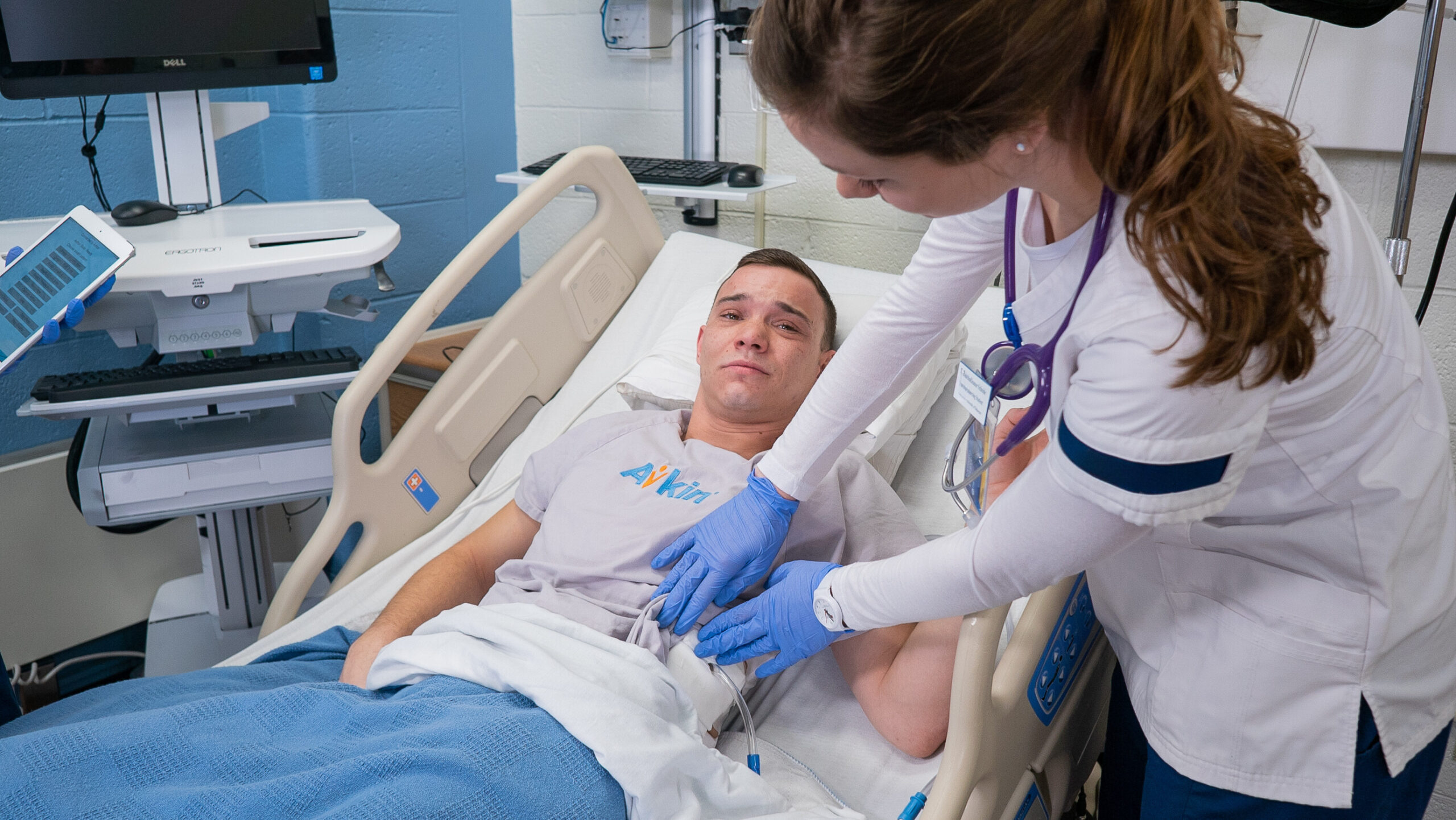 Patient with nursing student practicing chest tube management with Avkin's Avthor device, a wearable chest tube simulator.